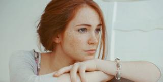 рыжая девушка задумалась